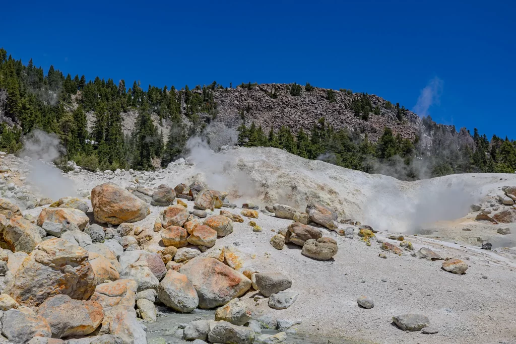 Steam rises in white plumes from three fumaroles at Bumpass Hell.