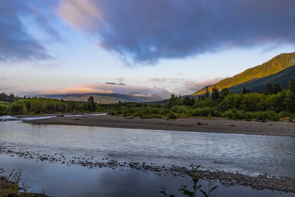 The sun begins to set, changing the clouds from grey to pink.