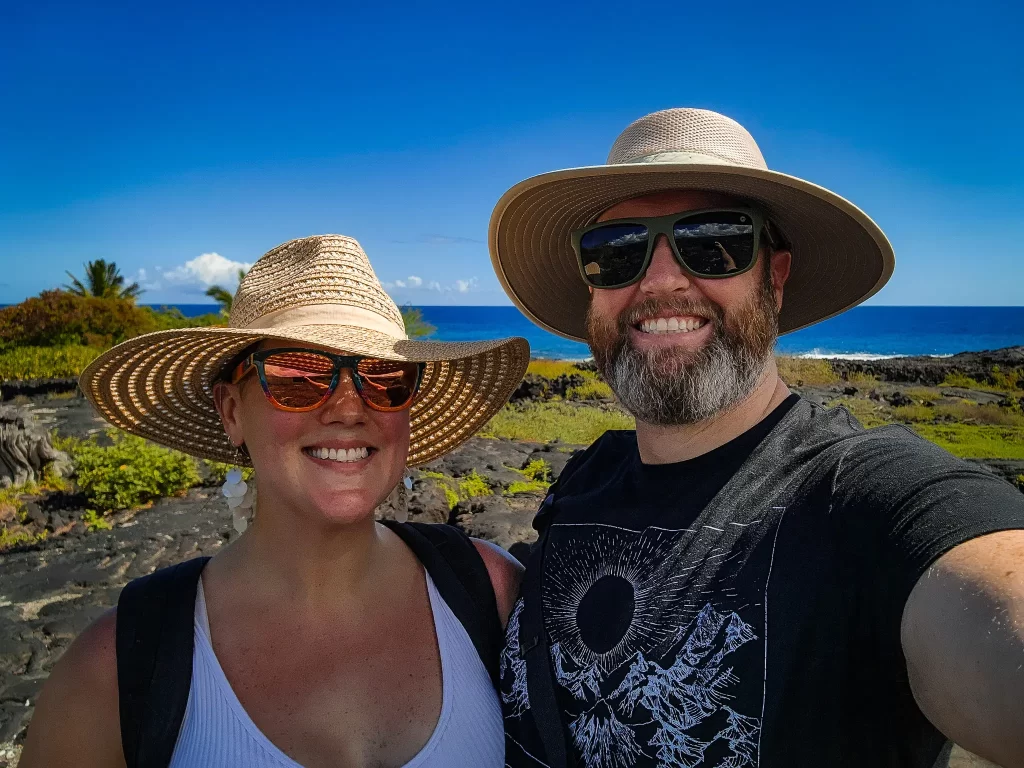 Elyse and Tom pose to remember their trip to Puʻuhonua o Hōnaunau National Historical Park.