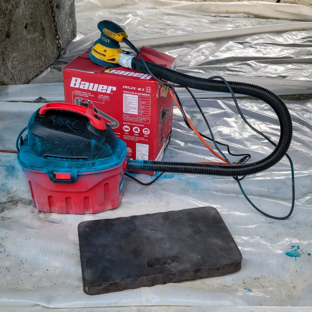 Orbit sander attached to vacuum for bottom paint prep.