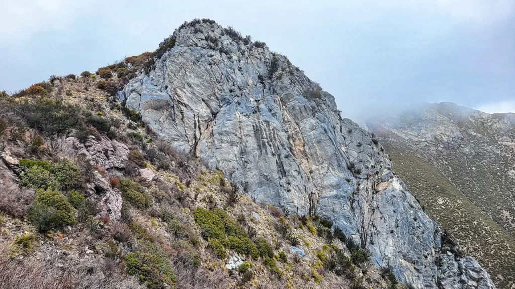 A blue-grey rocky outcropping emerges to one side of the Arizona Trail.