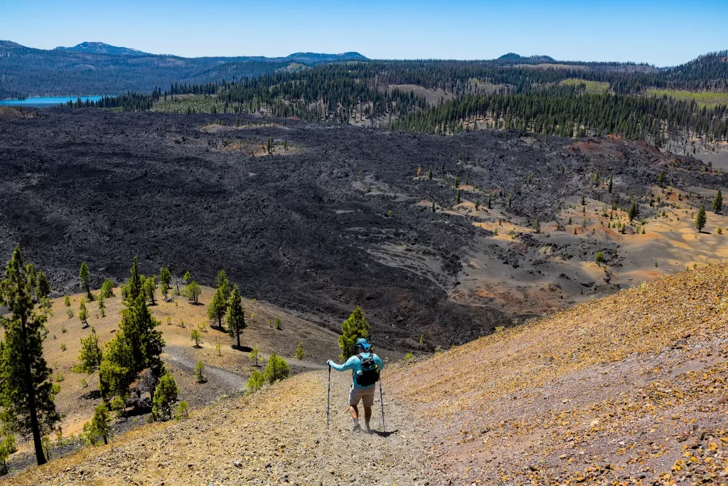 Tom uses trekking poles to descend the steep cinder cone.