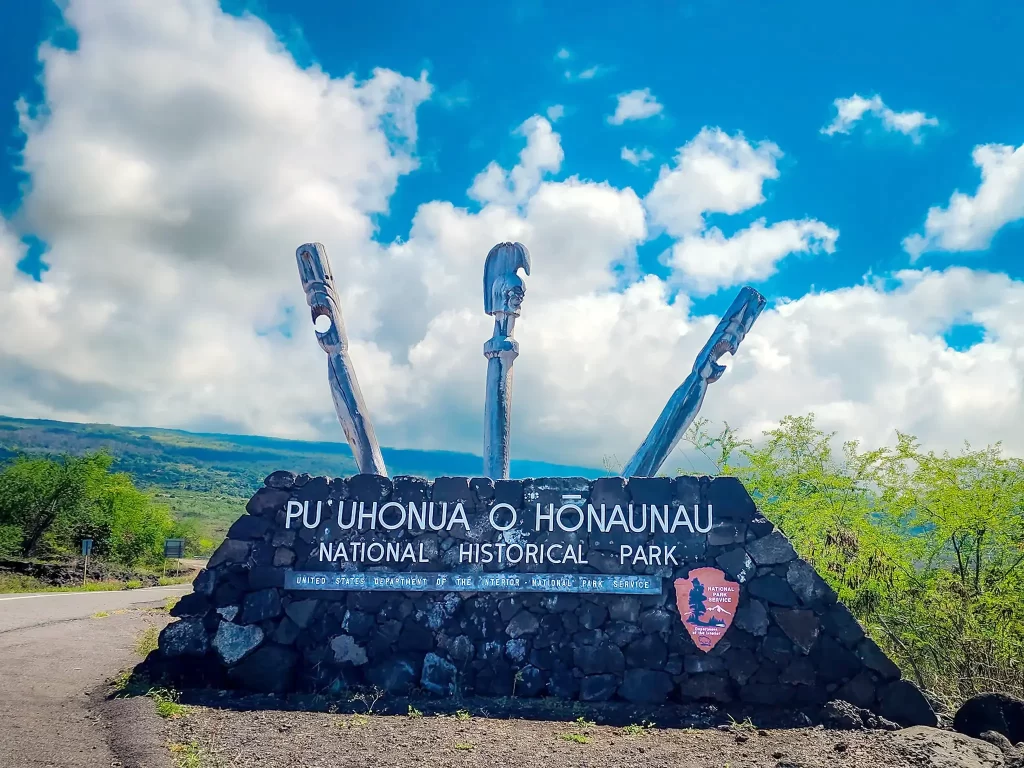 The sign to Puʻuhonua o Hōnaunau National Historical Park, feature three totems.