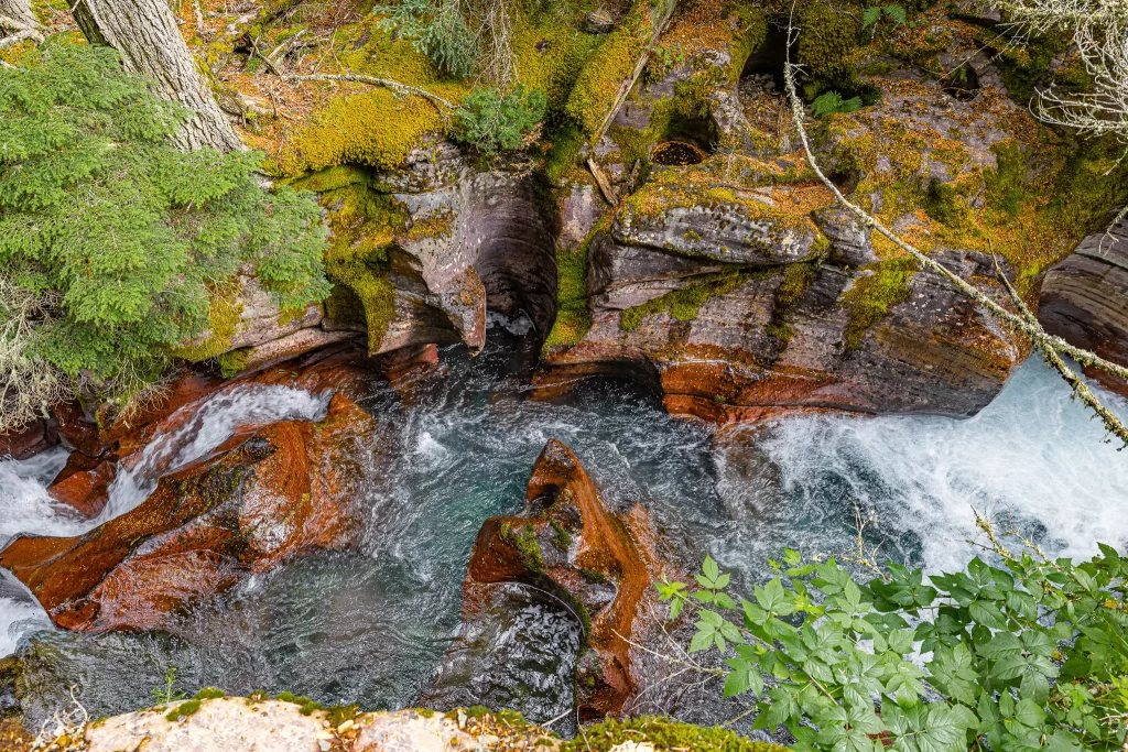 Blue waters swirl around worn rock.