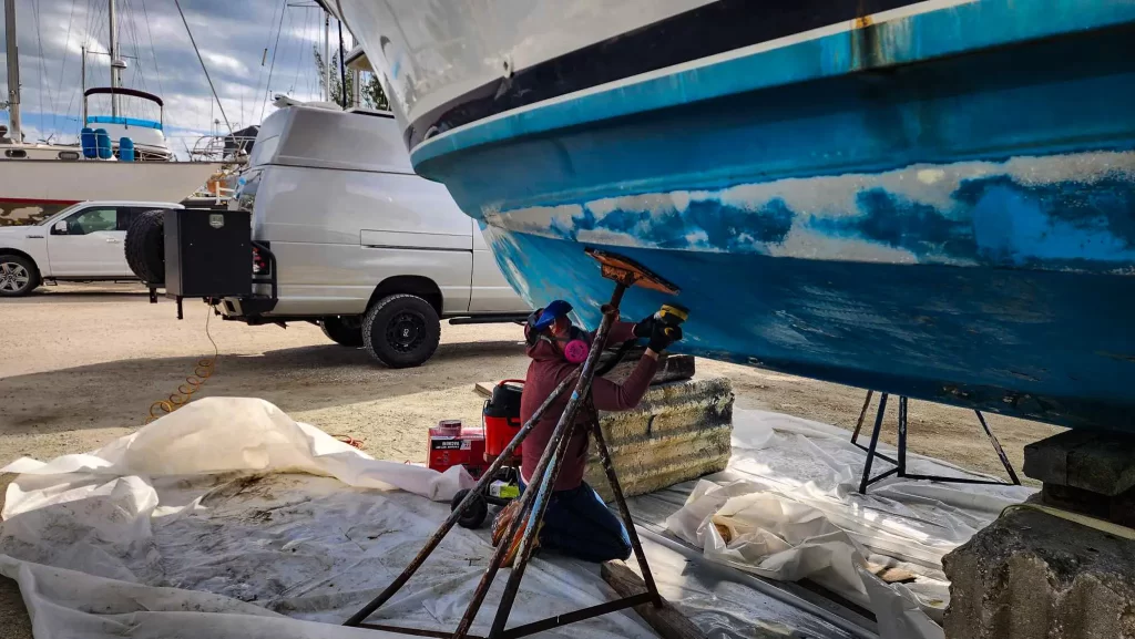 Elyse sanding the Carver Santego Yacht in preparation for bottom paint.