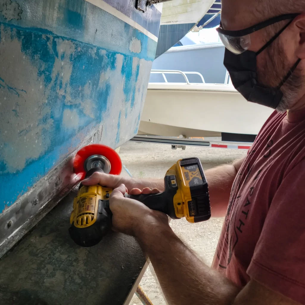 Tom using a drill to clean the Carver Yacht trim tabs.