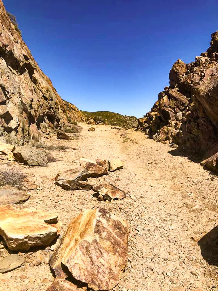 Red rocks rise to either side oof the Pacific Crest Trail.